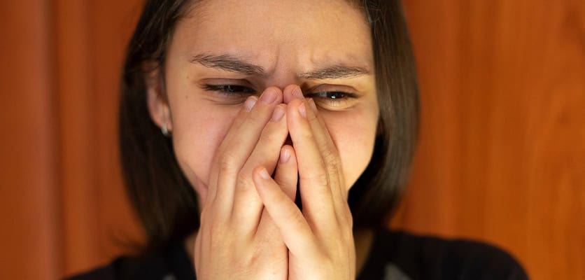 Woman covering nose, experiencing nasal congestion